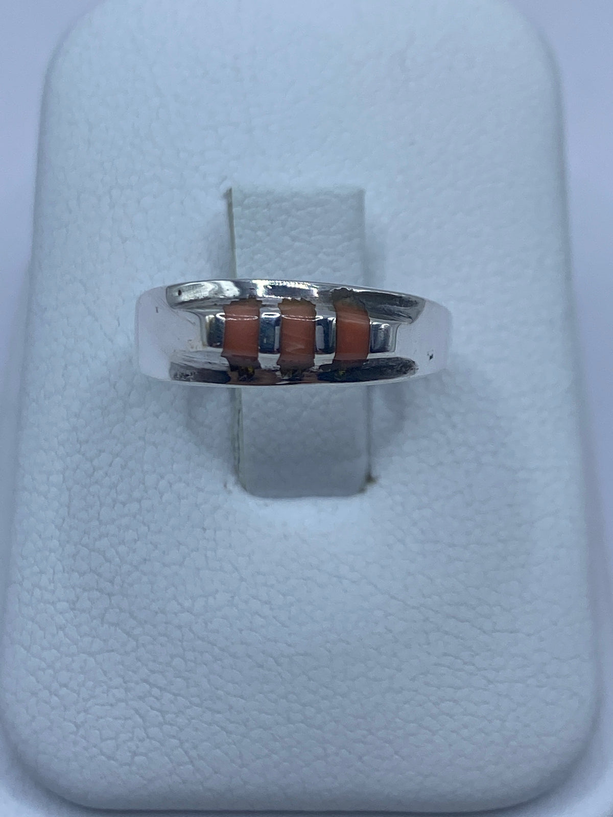 Anillo de plata 925 con coral natural engastado a mano, vista frontal sobre dedo