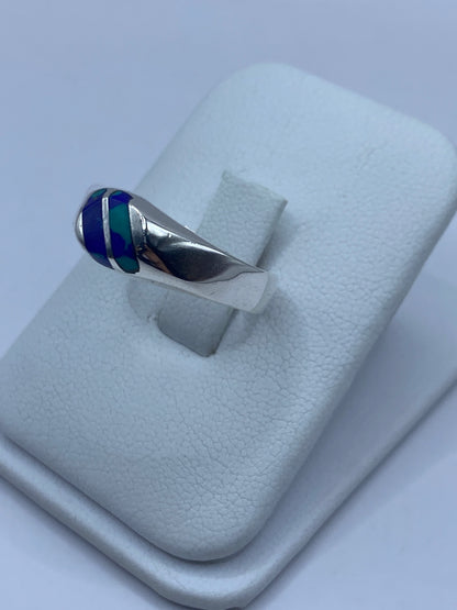 Detalle lateral del anillo mostrando el engaste a mano y la piedra azul