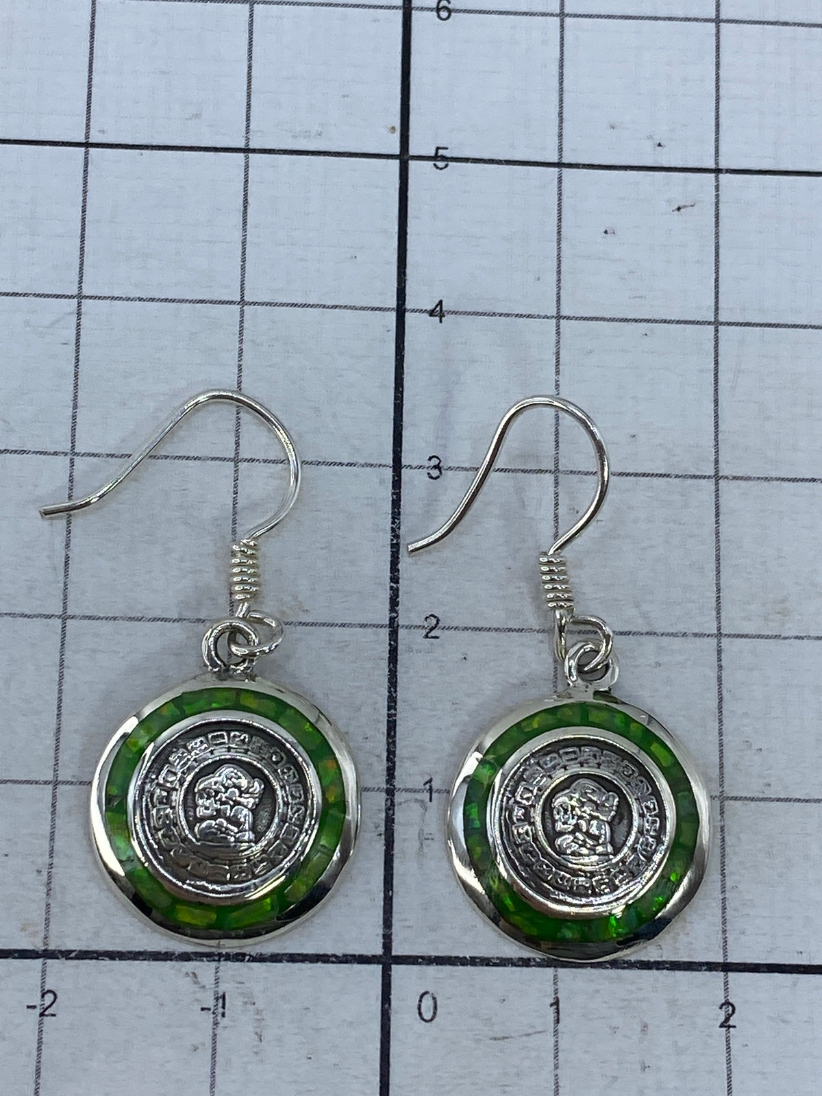 Aretes sobre fondo blanco mostrando el Quinto 950 y los ganchos de plata