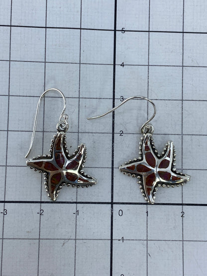 Aretes sobre cuadrícula de medición mostrando largo de 3 cm
