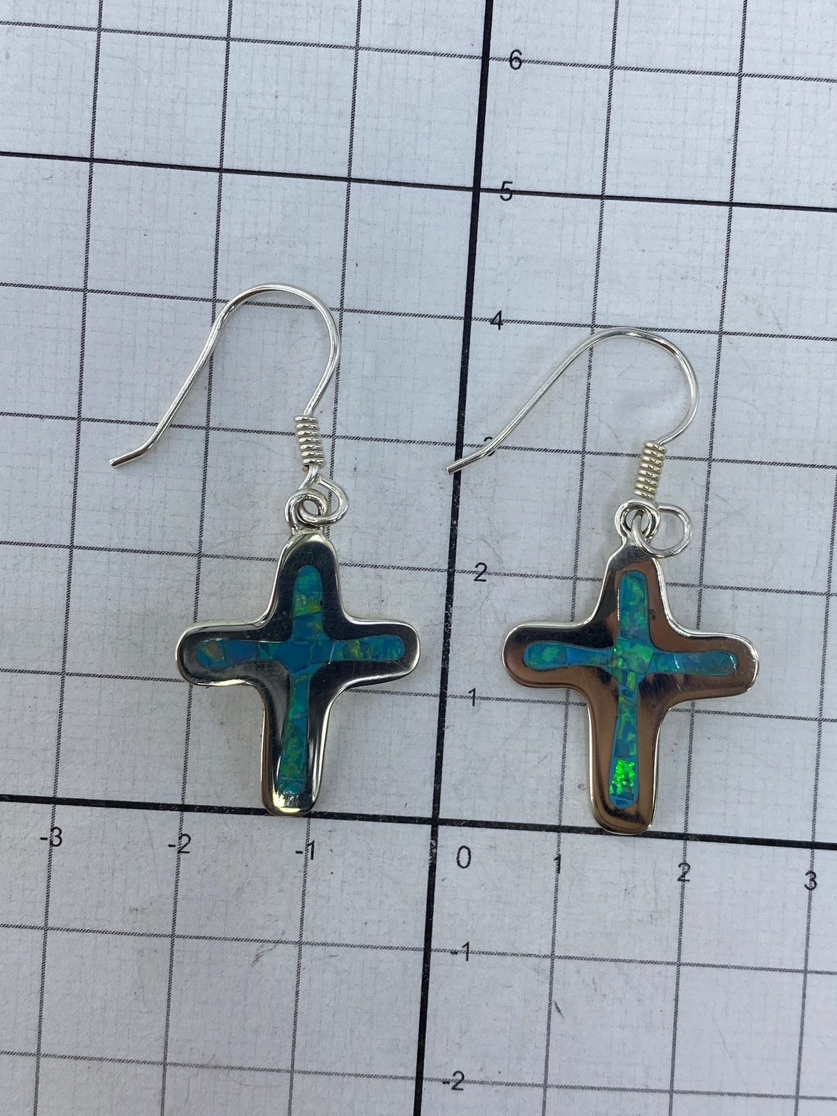 Los dos aretes sobre fondo blanco, con el Quinto 950 visible en la plata