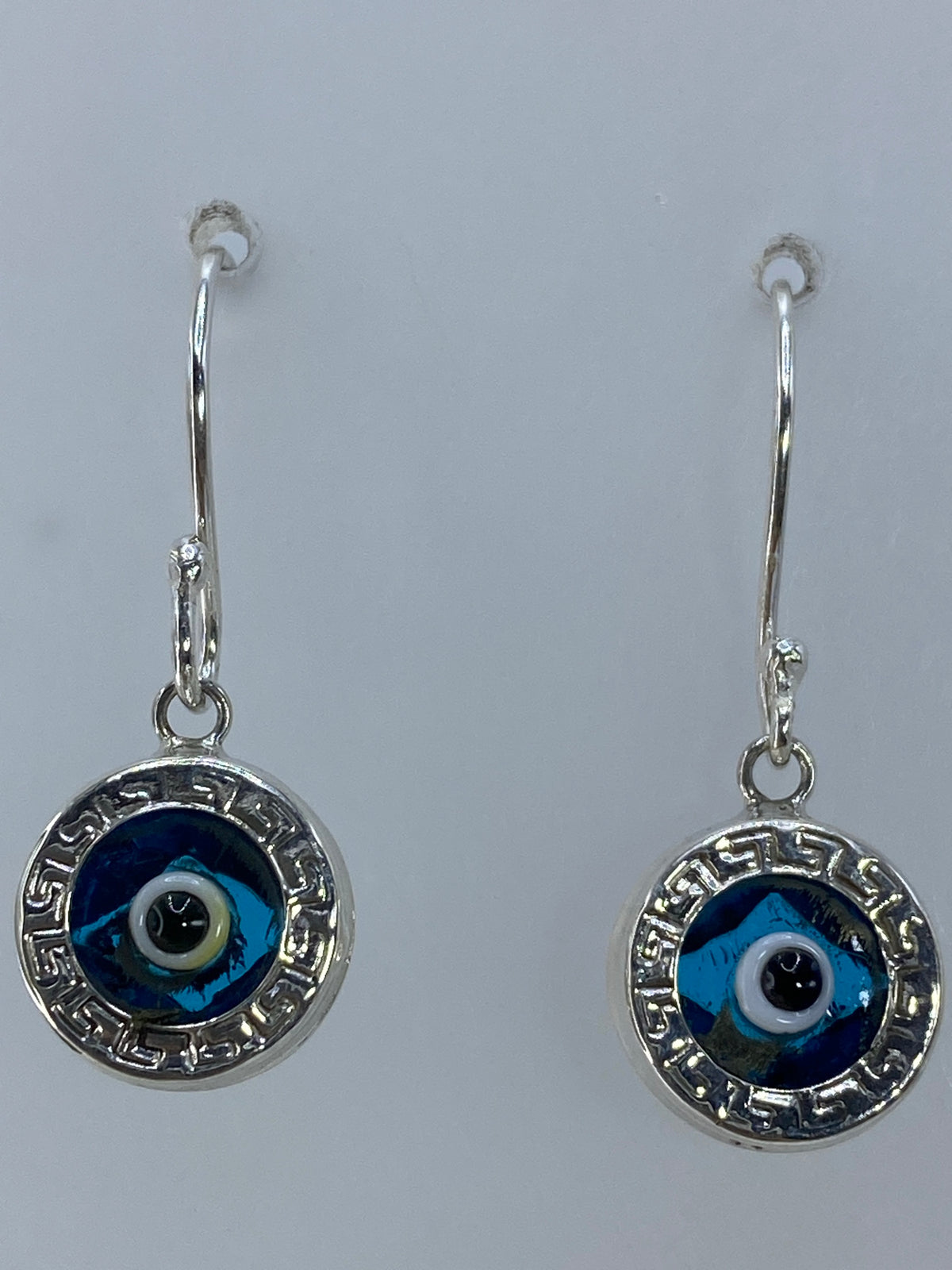Aretes sobre regla de medición mostrando largo de 2.6 cm