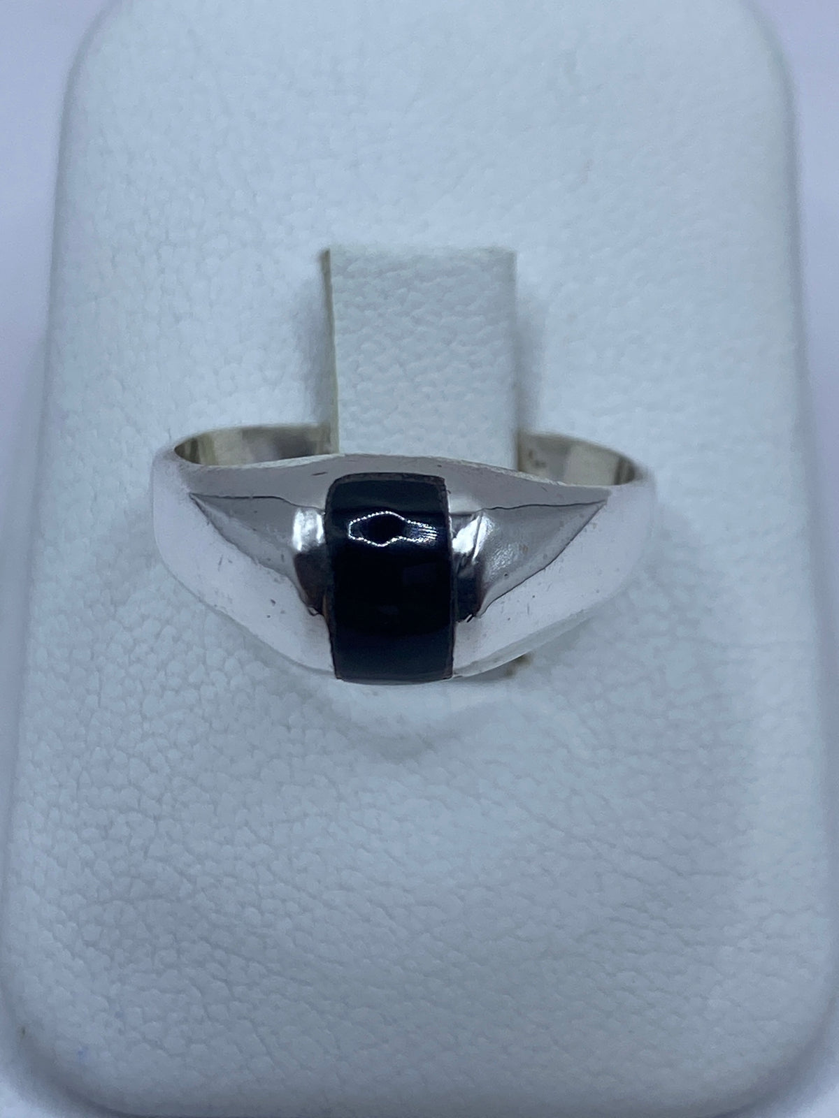 Anillo de plata 925 con onix negro engastado en la mano de un hombre