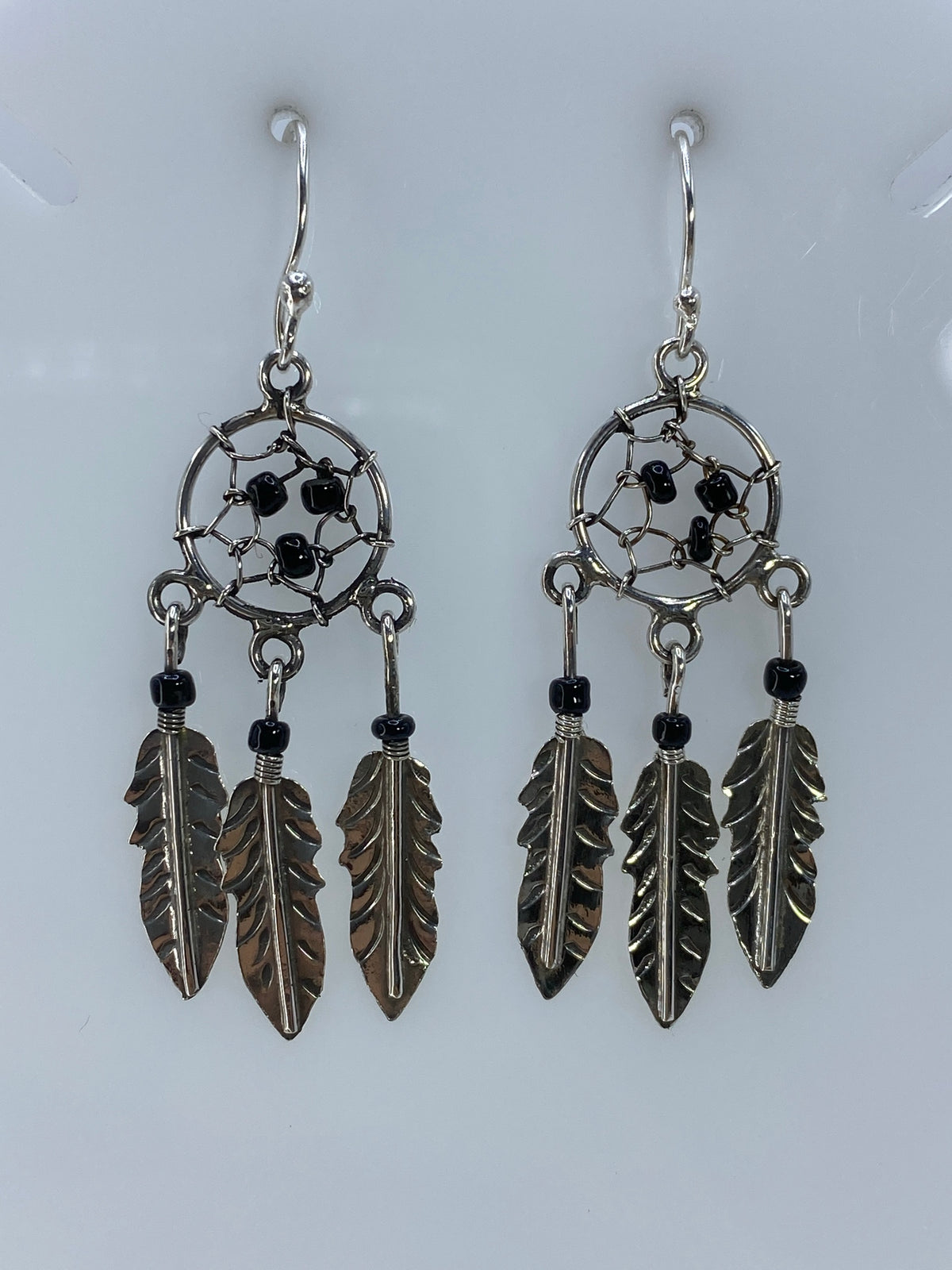 Vista frontal del par de aretes calados con patrón atrapasueños