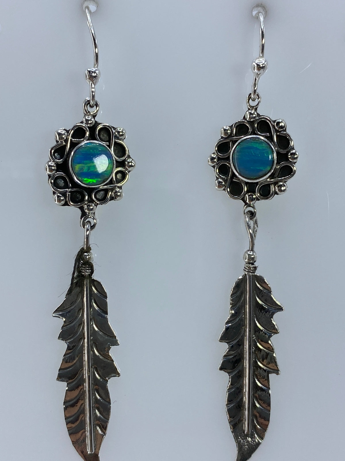 Par de aretes de plata con ópalo de fuego verde olivo y hojas martilladas, vista frontal