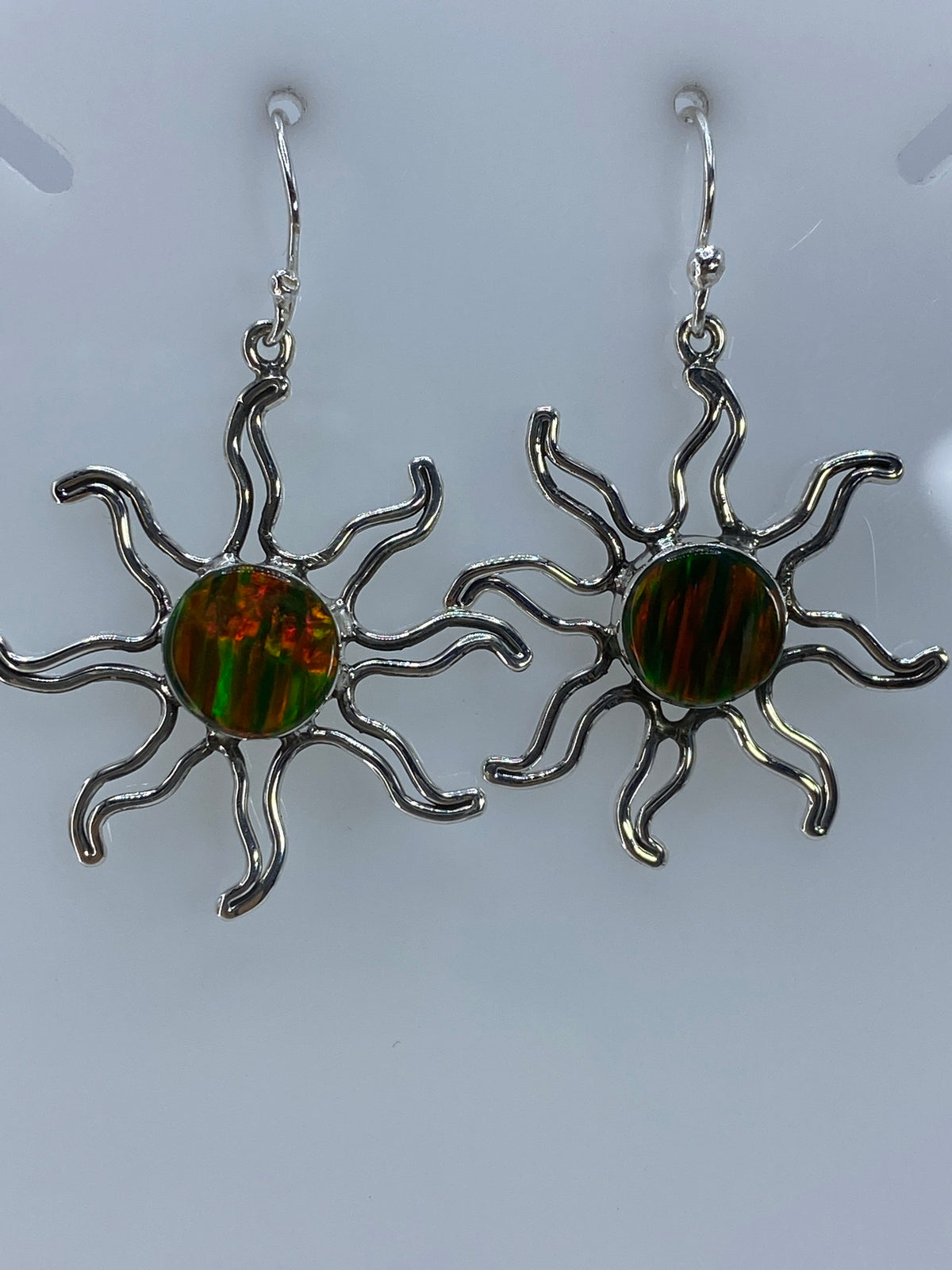 Par de aretes de plata 950 con ópalo de Fuego multicolor engastado, colgando en fondo gris