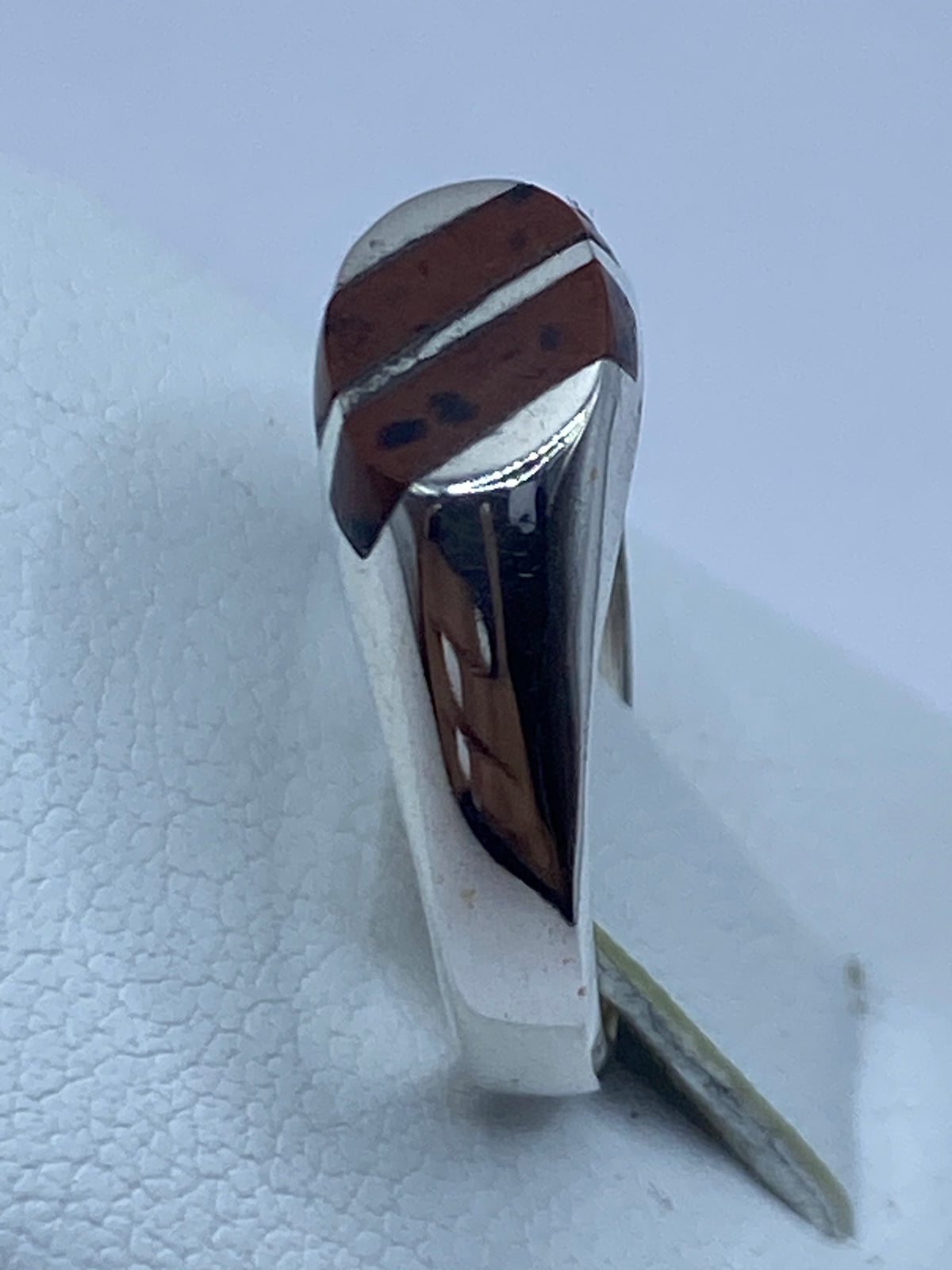 Anillo de plata en la mano, con luz que resalta el brillo de la piedra
