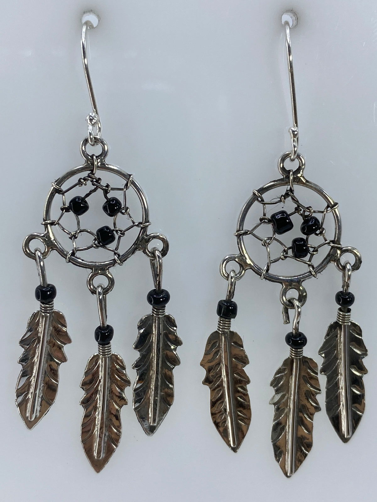 Par de aretes atrapasueños de plata 925 con telaraña y plumas, colgando de los lóbulos
