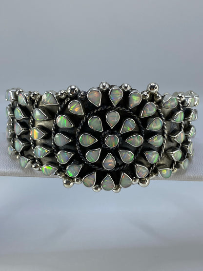 Brazalete de plata 950 con ópalo de fuego multicolor engastado, vista frontal sobre fondo gris