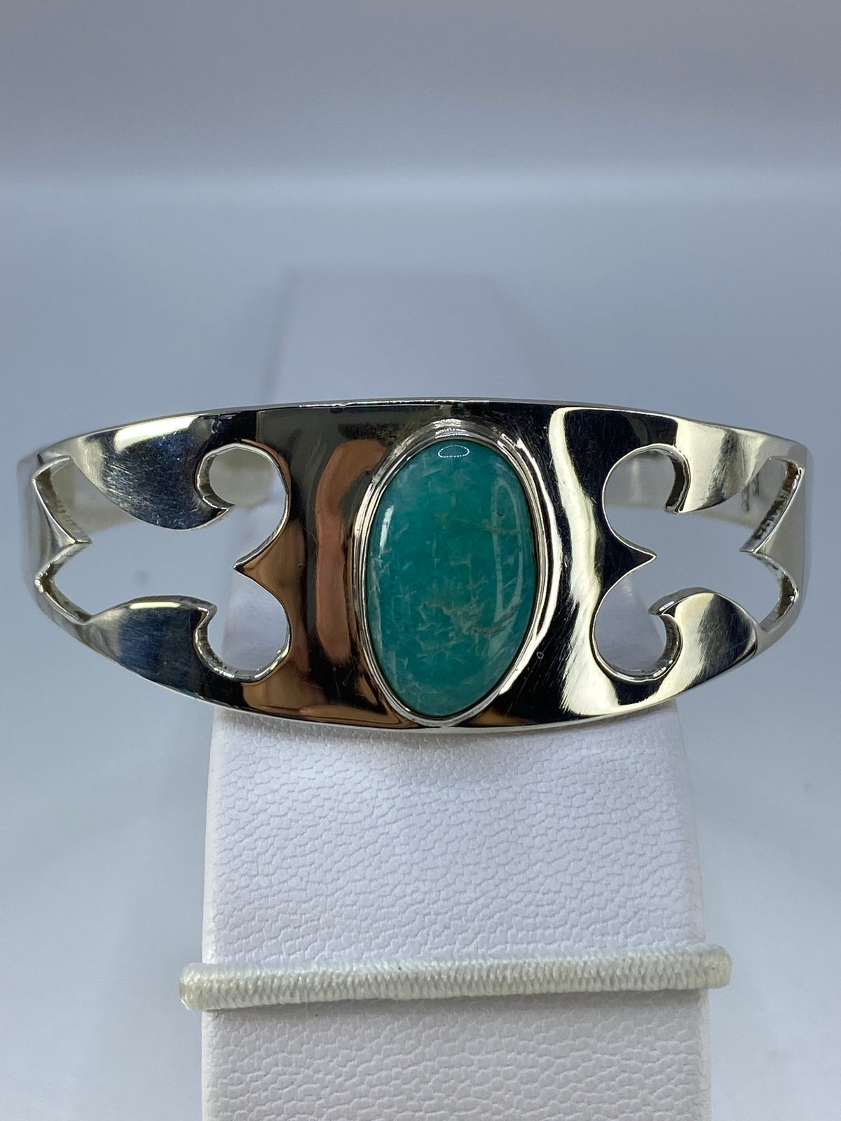 Brazalete rígido de plata 925 con turquesa azul en la muñeca de una mujer