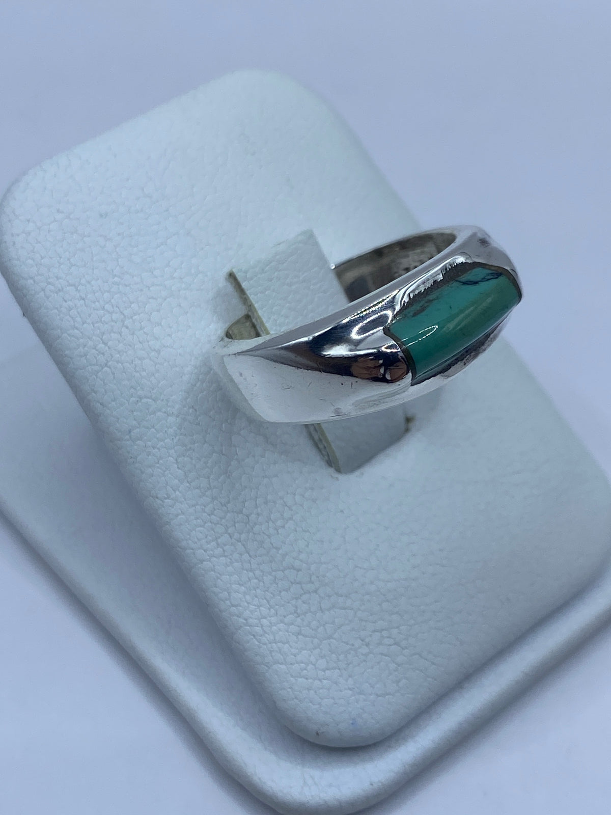 Detalle lateral del anillo mostrando el engaste de la turquesa en plata
