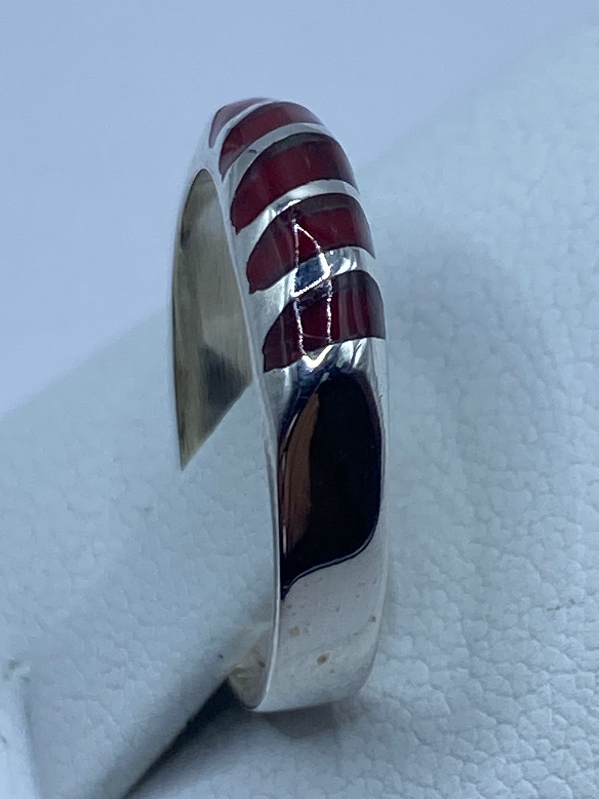 Anillo puesto en el dedo mostrando el tono rojo intenso del coral