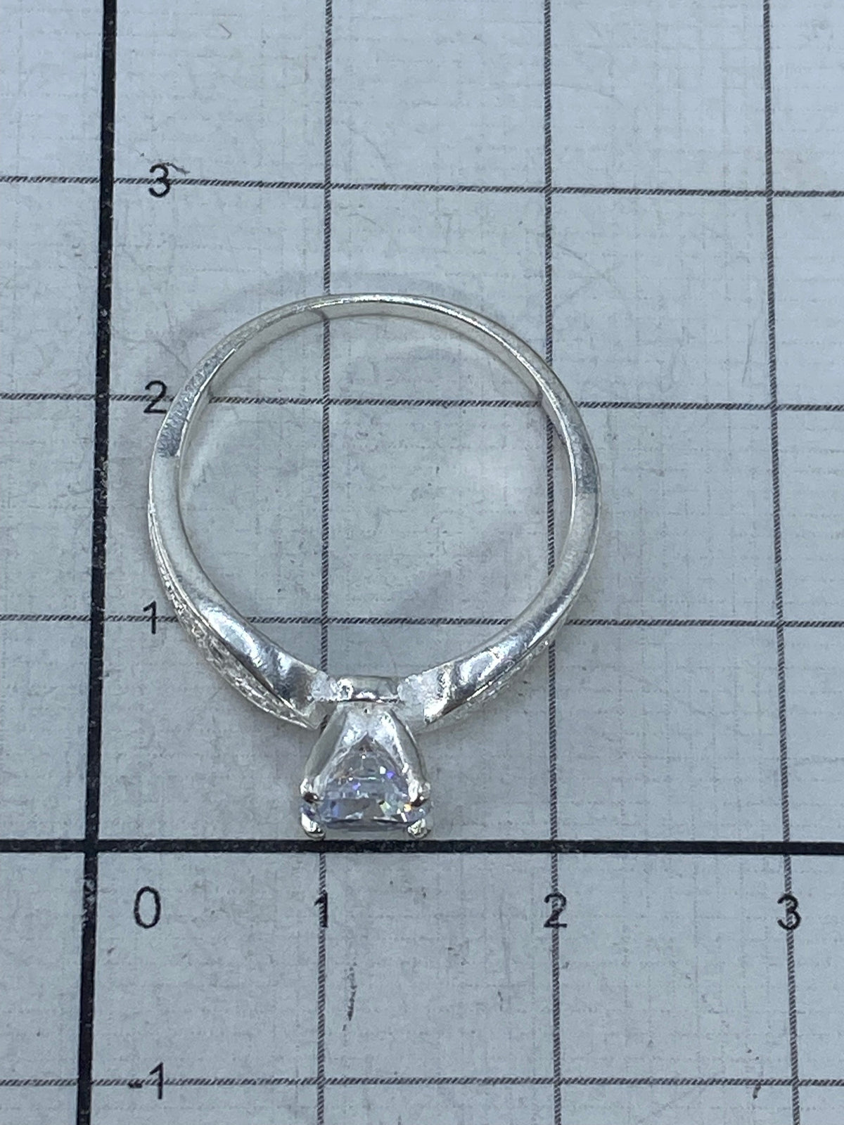 Anillo sobre fondo blanco mostrando el brillo de la circonia y la plata
