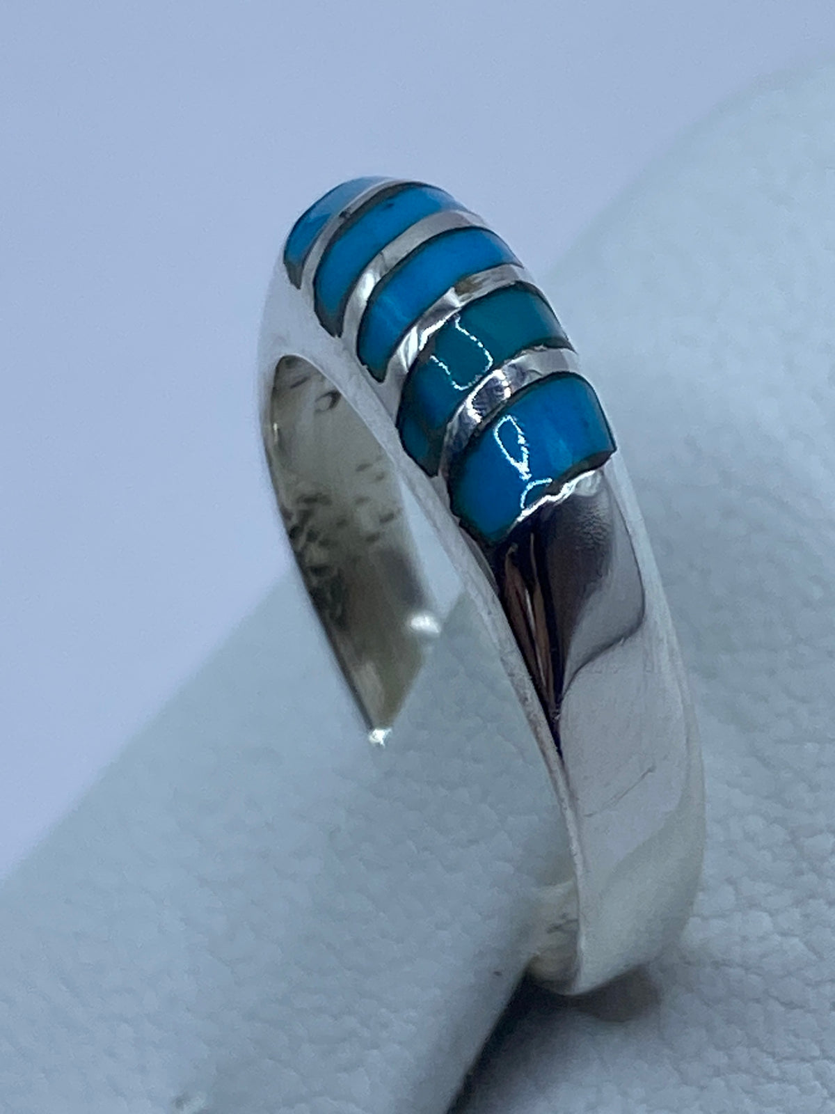 Detalle lateral del anillo con turquesa azul en engaste de plata, en dedo