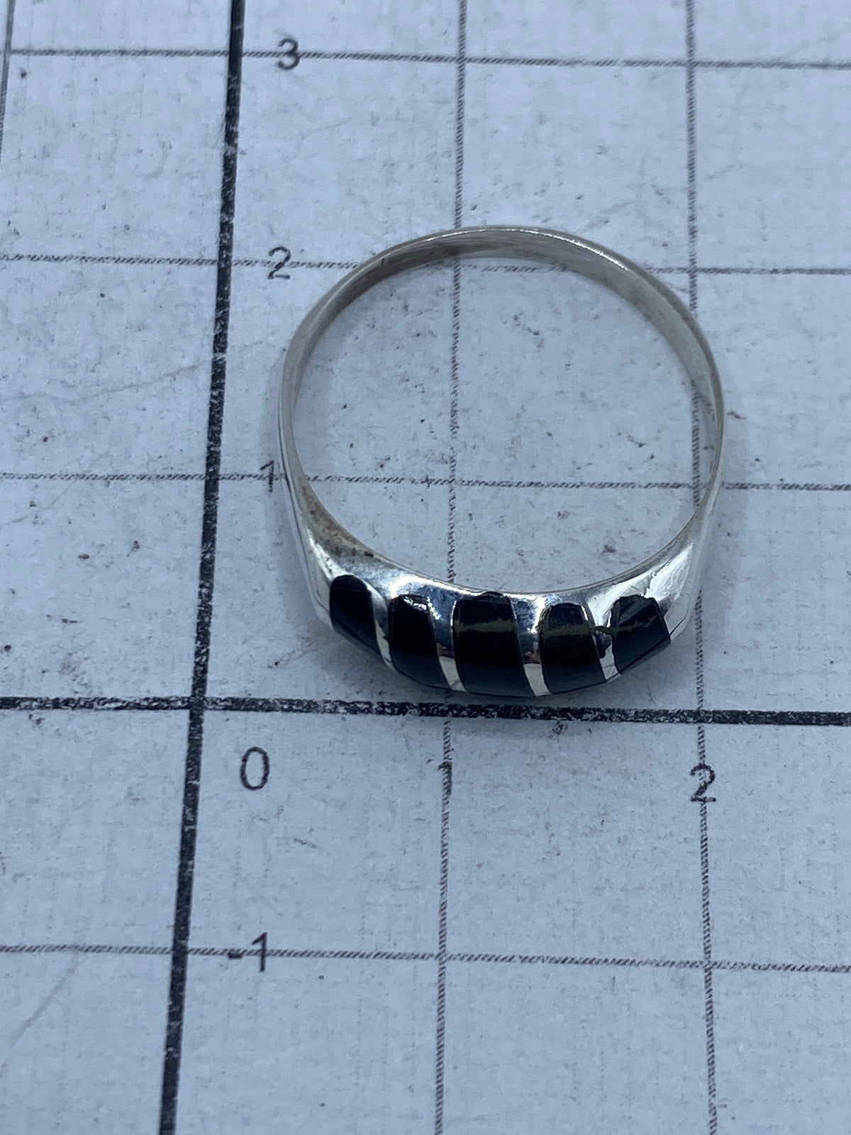 Anillo sobre fondo blanco exhibiendo el Quinto 950 en el interior