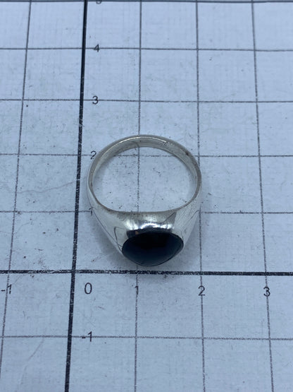 Anillo puesto en la mano mostrando el acabado pulido y el ónix negro brillante