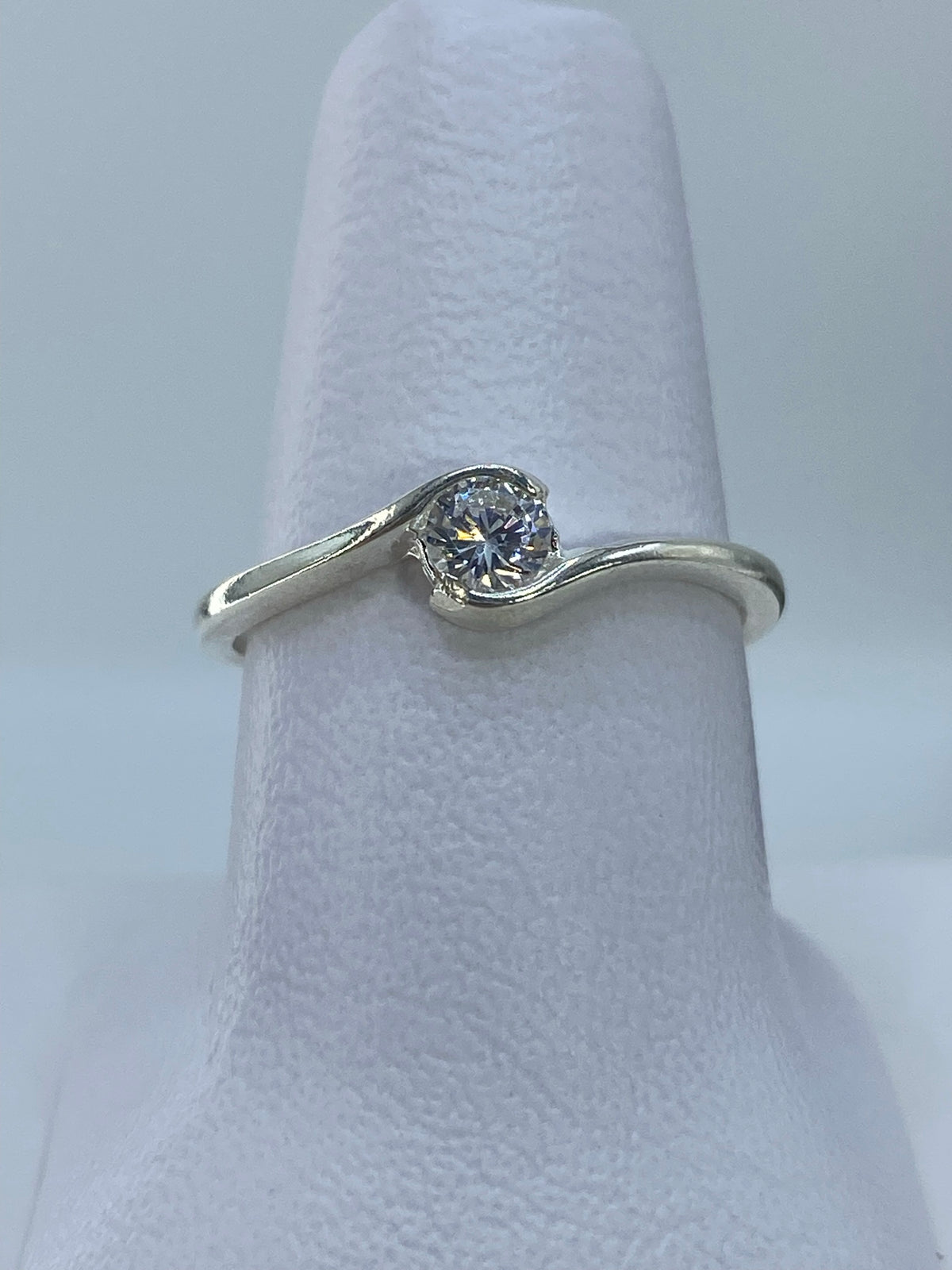Anillo de plata solitario con circonia cristalina en dedo de mujer