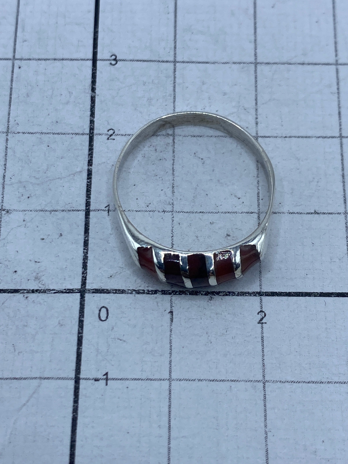 Vista superior del anillo sobre regla centimetrada, con certificado de peso SKU