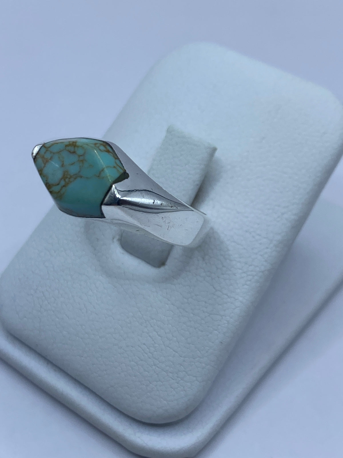 Detalle lateral del anillo mostrando el engaste a mano de la turquesa