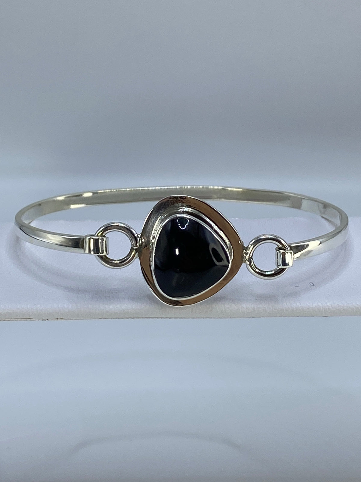 Brazalete de plata con ónix negro en muñeca de mujer