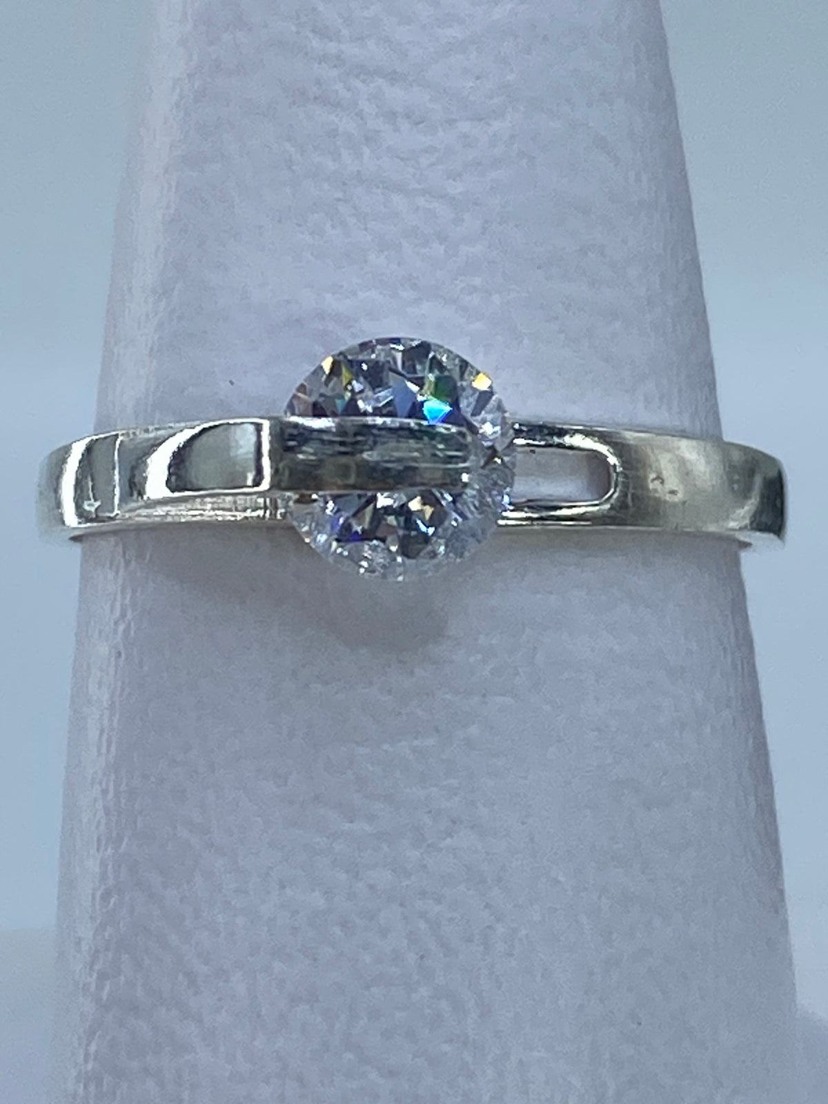 Anillo solitario sobre escala métrica mostrando proporciones de la piedra