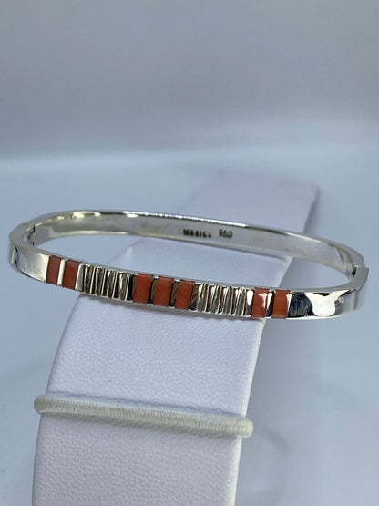 Brazalete de plata tipo puño en la muñeca, mostrando el ancho de la banda