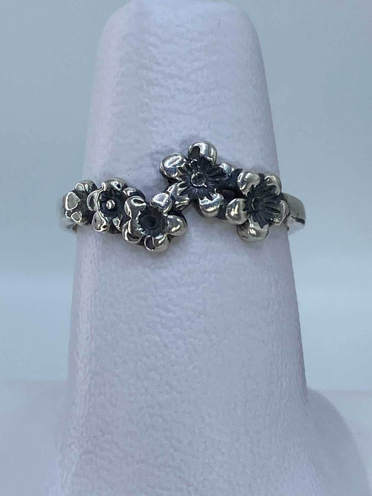 Anillo de plata repujado con flores en relieve en mano de mujer