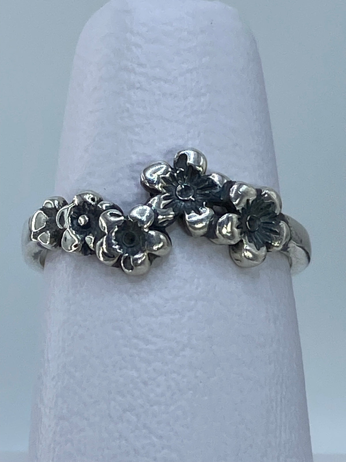 Anillo puesto en mano, visibles las tres flores repujadas