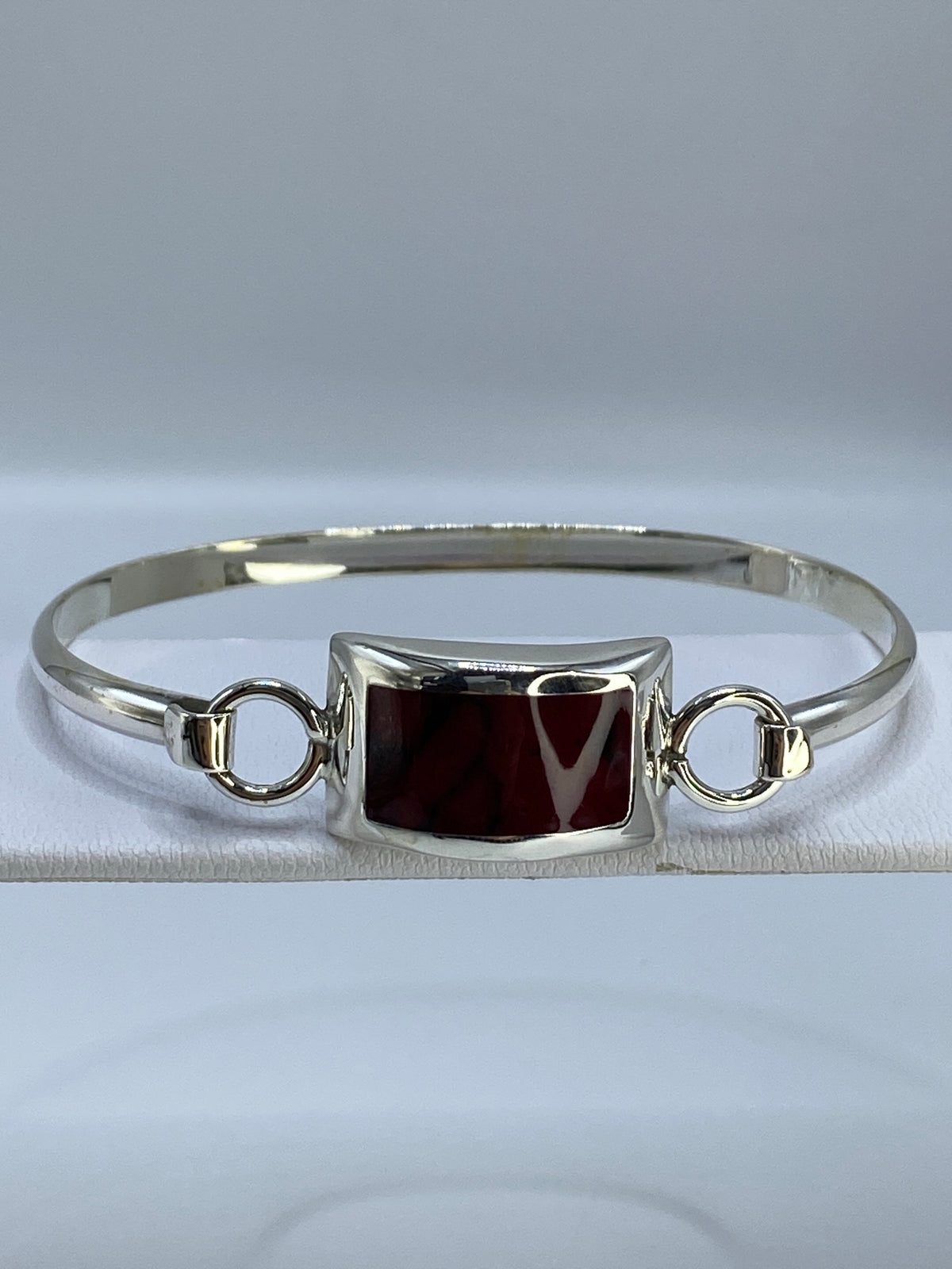 Brazalete de plata 925 rígido con coral rojo engastado en la muñeca
