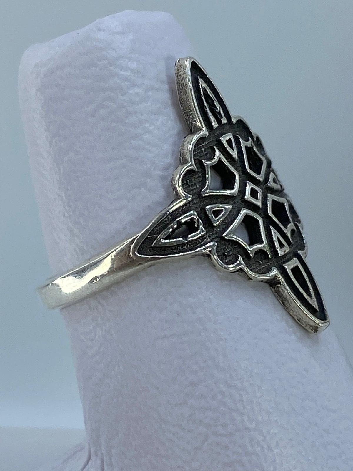 Anillo nudo de bruja en la mano mostrando el relieve del repujado