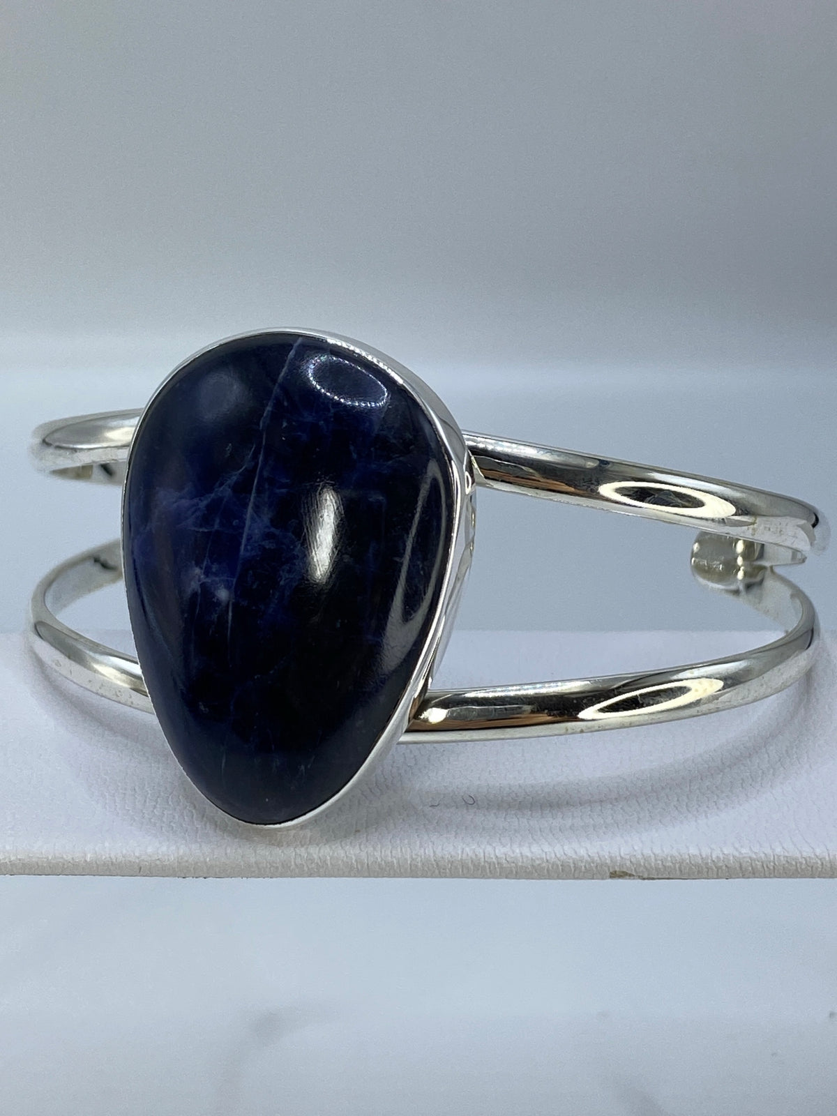 Brazalete abierto en plata con piedra lapislázuli, mostrando la amplitud de la banda de 4.3 cm
