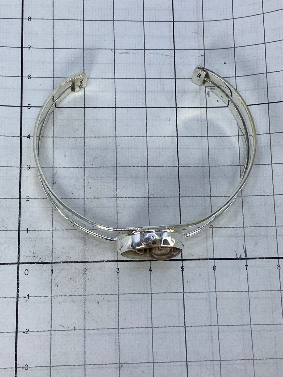 Brazalete sobre escala de centímetros mostrando medidas precisas: 6.1 cm diámetro interior