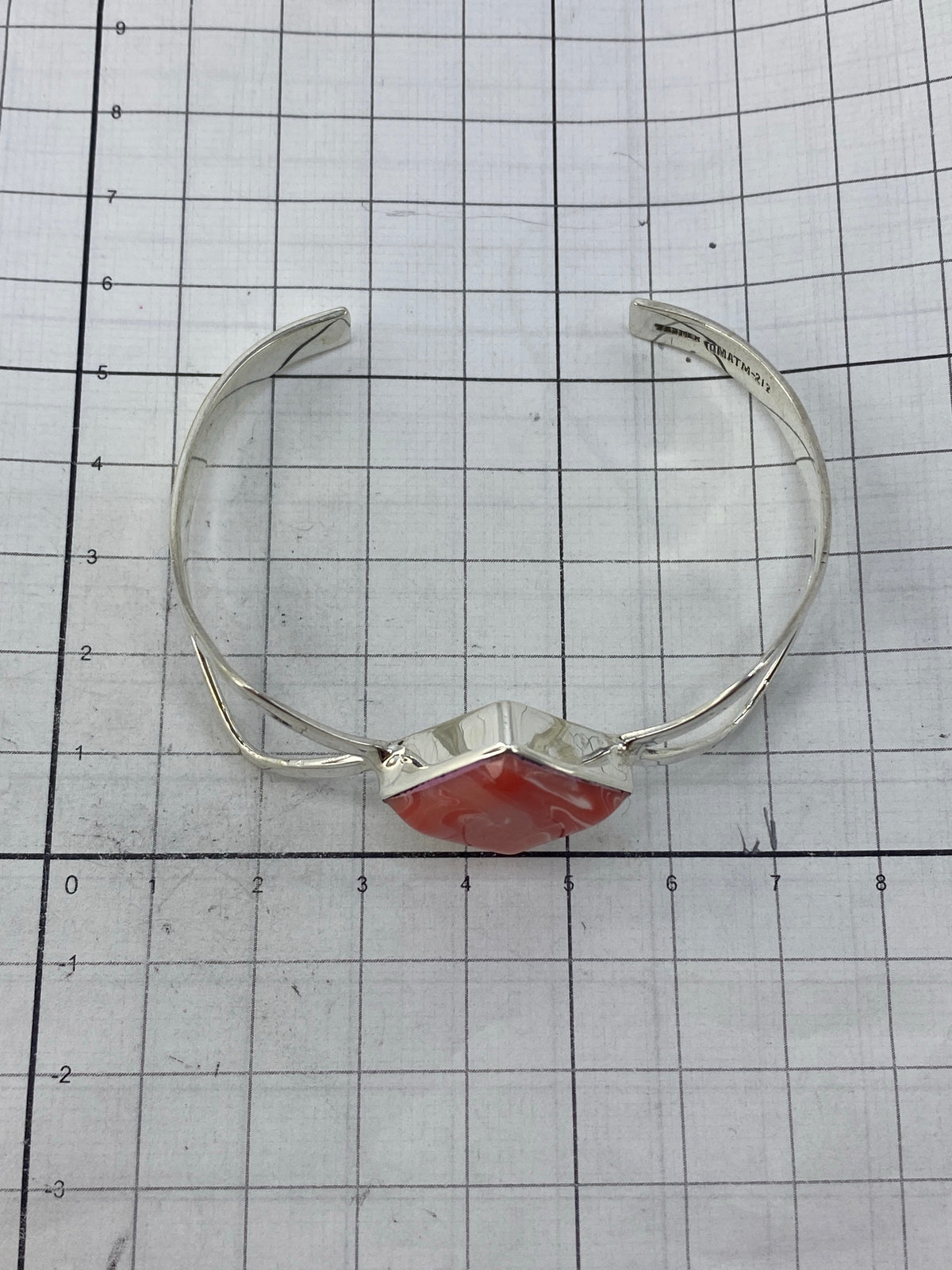 Brazalete de plata 925 abierto con marca de autenticidad, mostrando el coral rosa interior