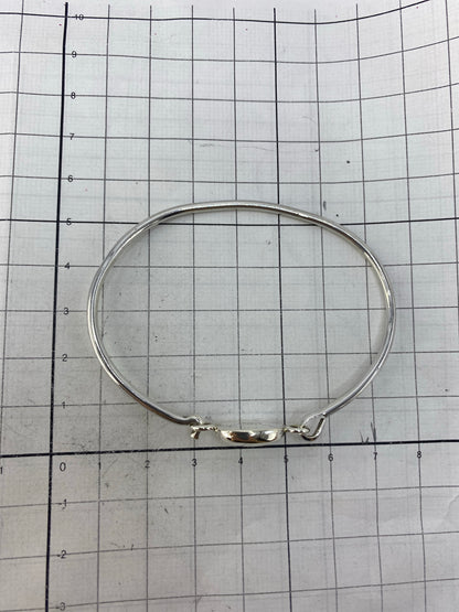 Brazalete puesto en la muñeca mostrando el tono verde olivo de la piedra