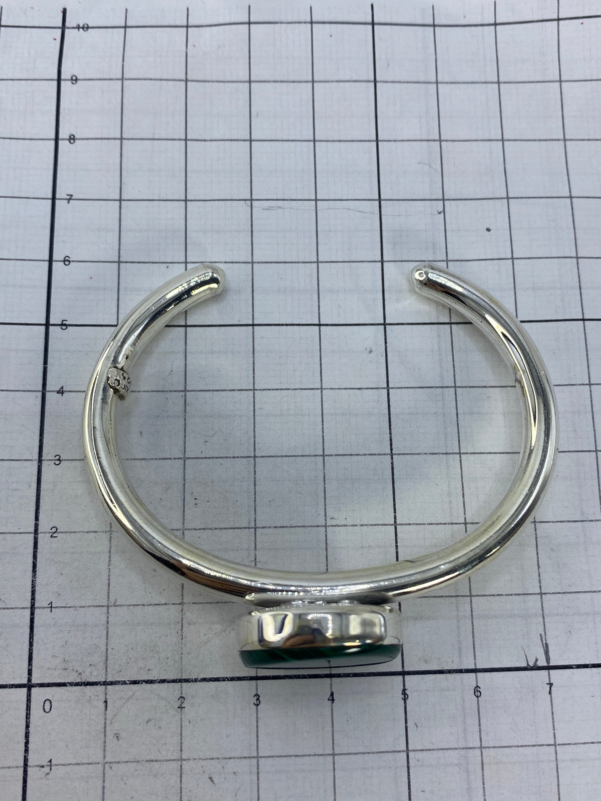 Brazalete sobre escala de centímetros confirmando diámetro interior 6.7 cm y ancho 4.5 cm