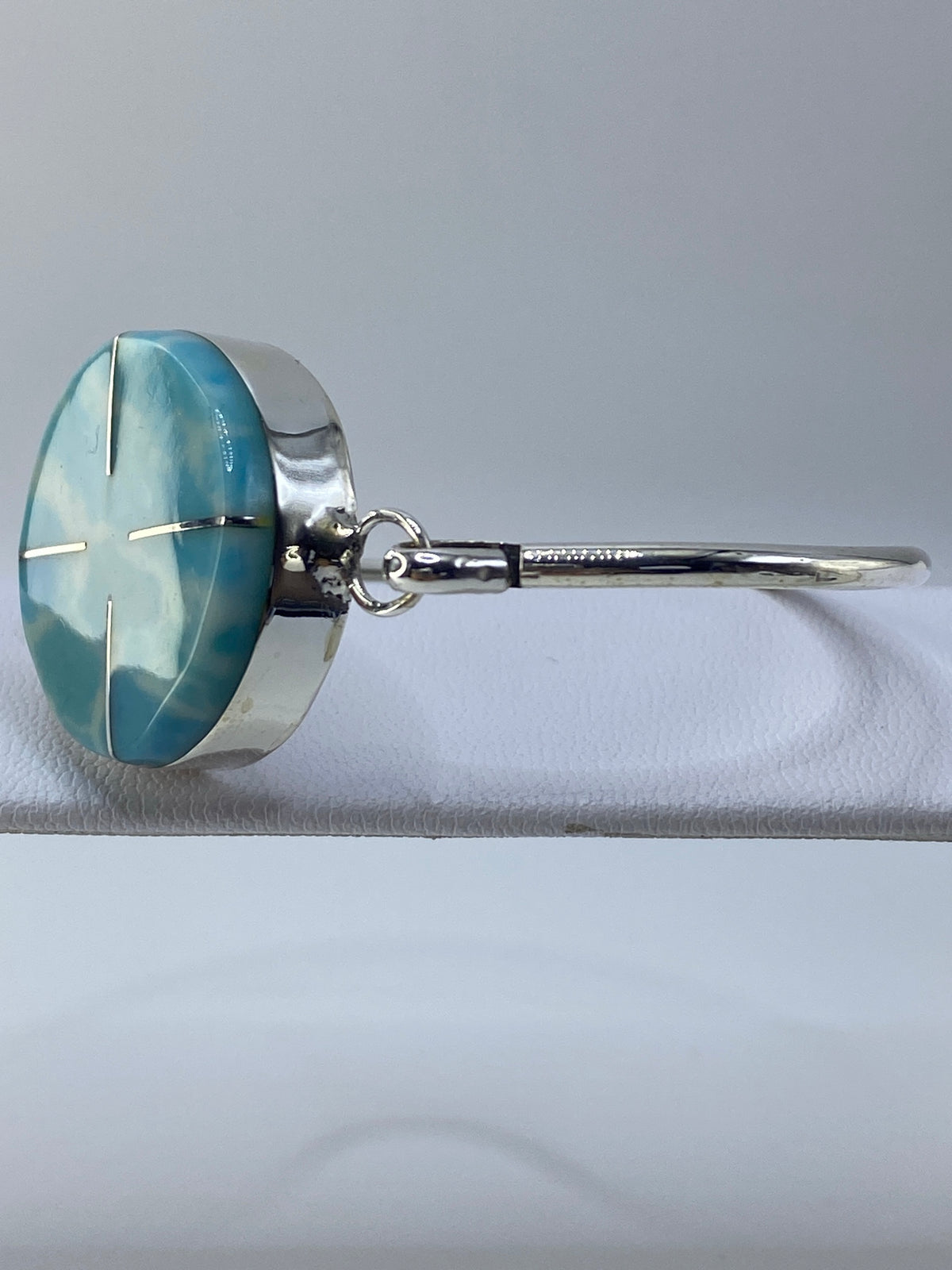 Brazalete puesto en la muñeca, vista lateral, turquesa brillante sobre plata pulida