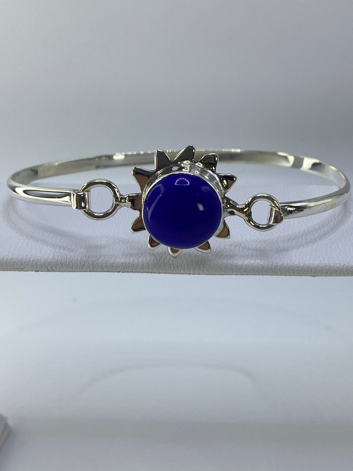 Brazalete rígido de plata con lapislázuli azul intenso en la muñeca de una mujer