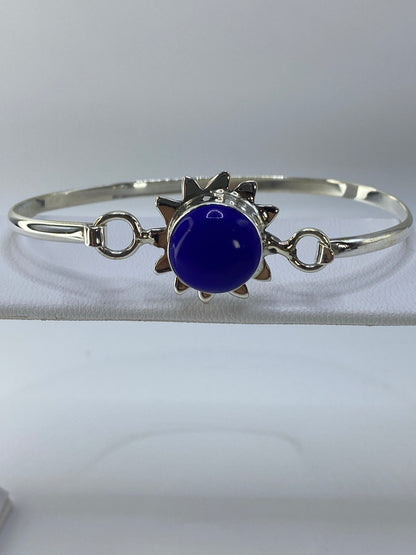 Brazalete rígido de plata con lapislázuli azul intenso en la muñeca de una mujer