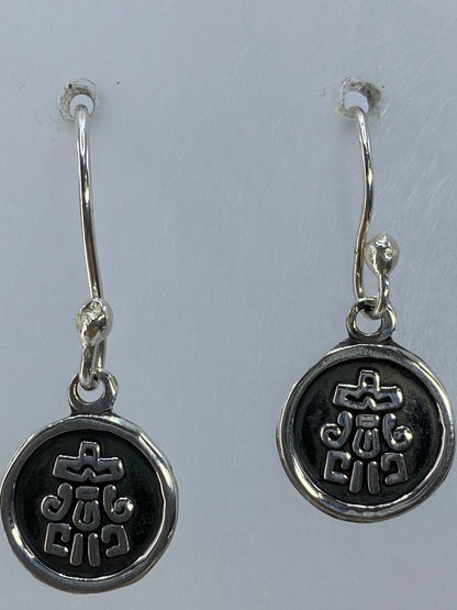 Aretes religiosos de 2.5 cm de largo sobre fondo neutro