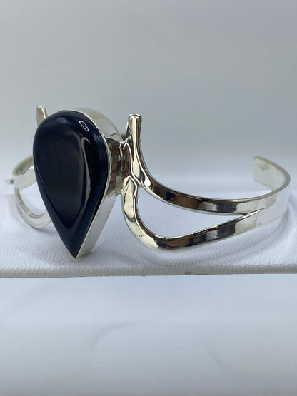 Vista frontal del brazalete mostrando la piedra ónix negra y la abertura lateral