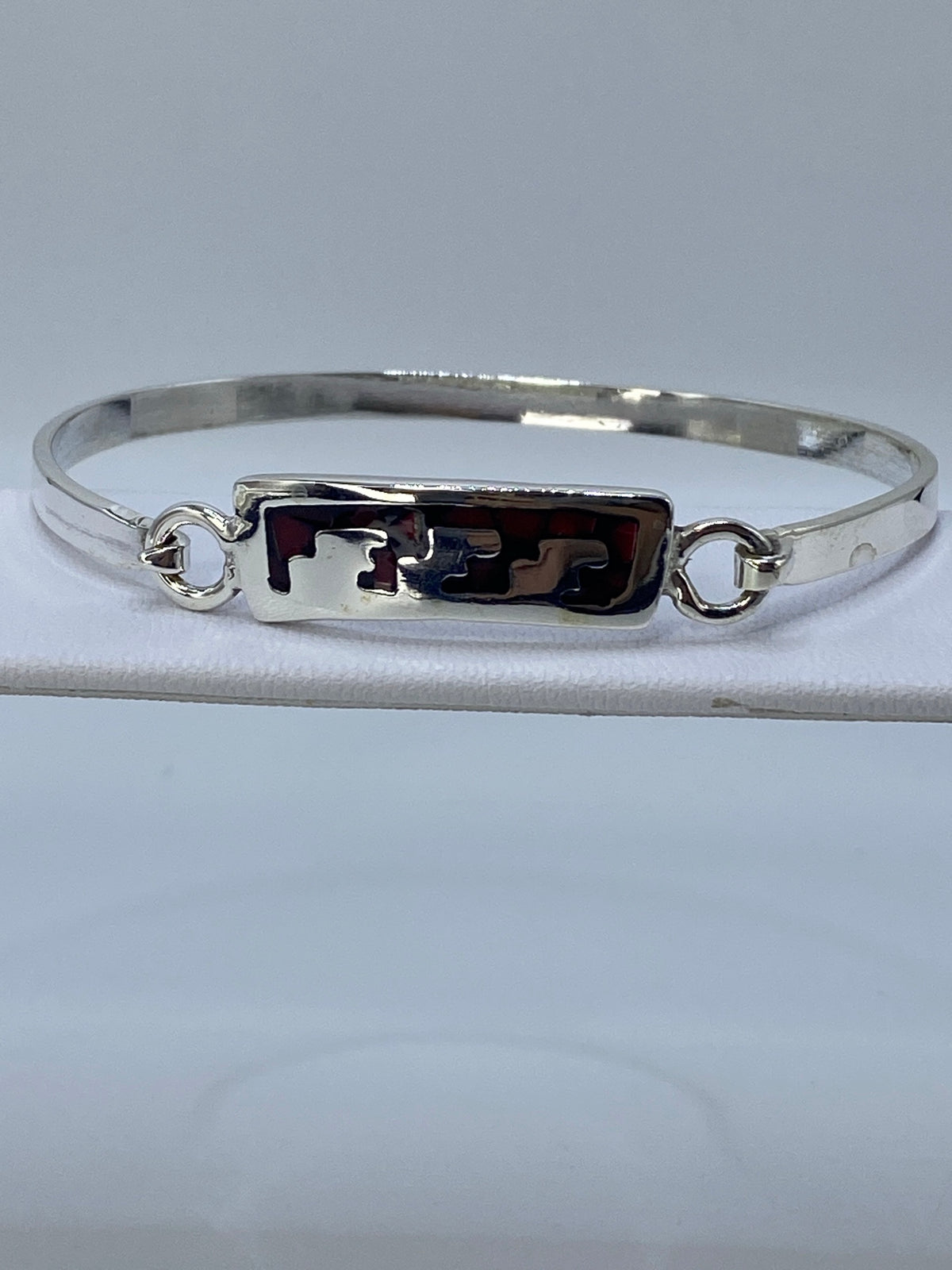 Brazalete de plata 925 con coral rojo engastado, abierto sobre fondo blanco