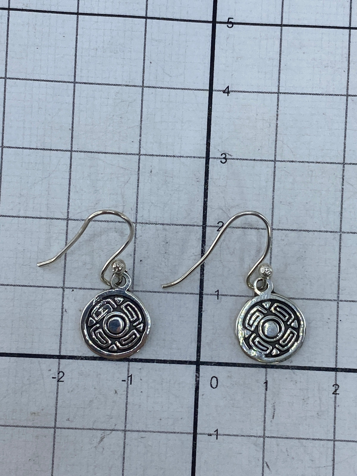Aretes en la mano mostrando el tamaño compacto y el acabado pulido