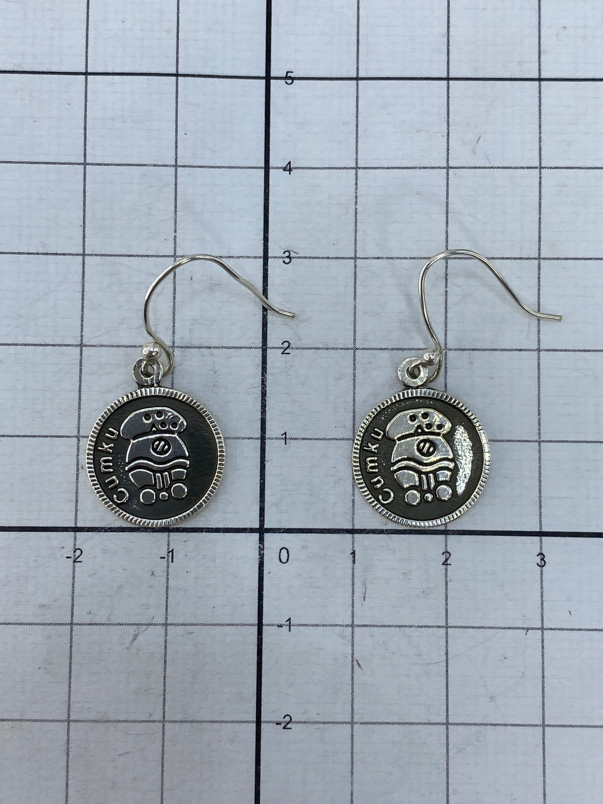 Reverso de los aretes mostrando el sello Cumikú y el Quinto 925