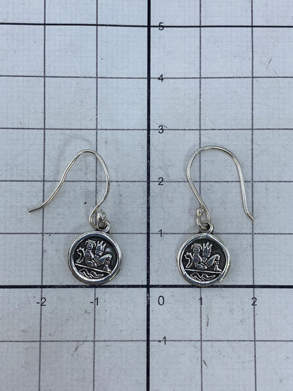 Aretes de plata sobre fondo blanco mostrando el Quinto 925 en el reverso