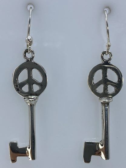 Aretes de plata paz sobre escala con medida de 4 cm de largo