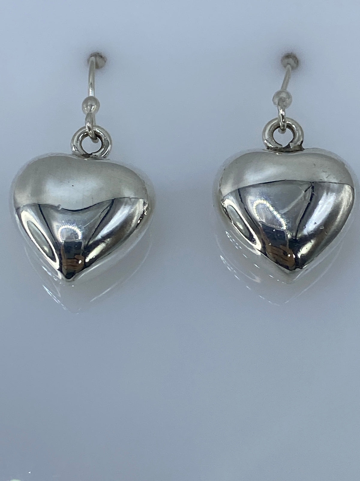 Aretes de corazón en fundición de plata — vista frontal mostrando el brillo pulido