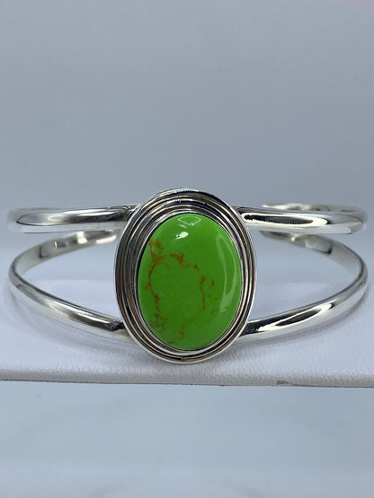 Brazalete rígido de plata 950 con turquesa verde limón, vista frontal en el antebrazo