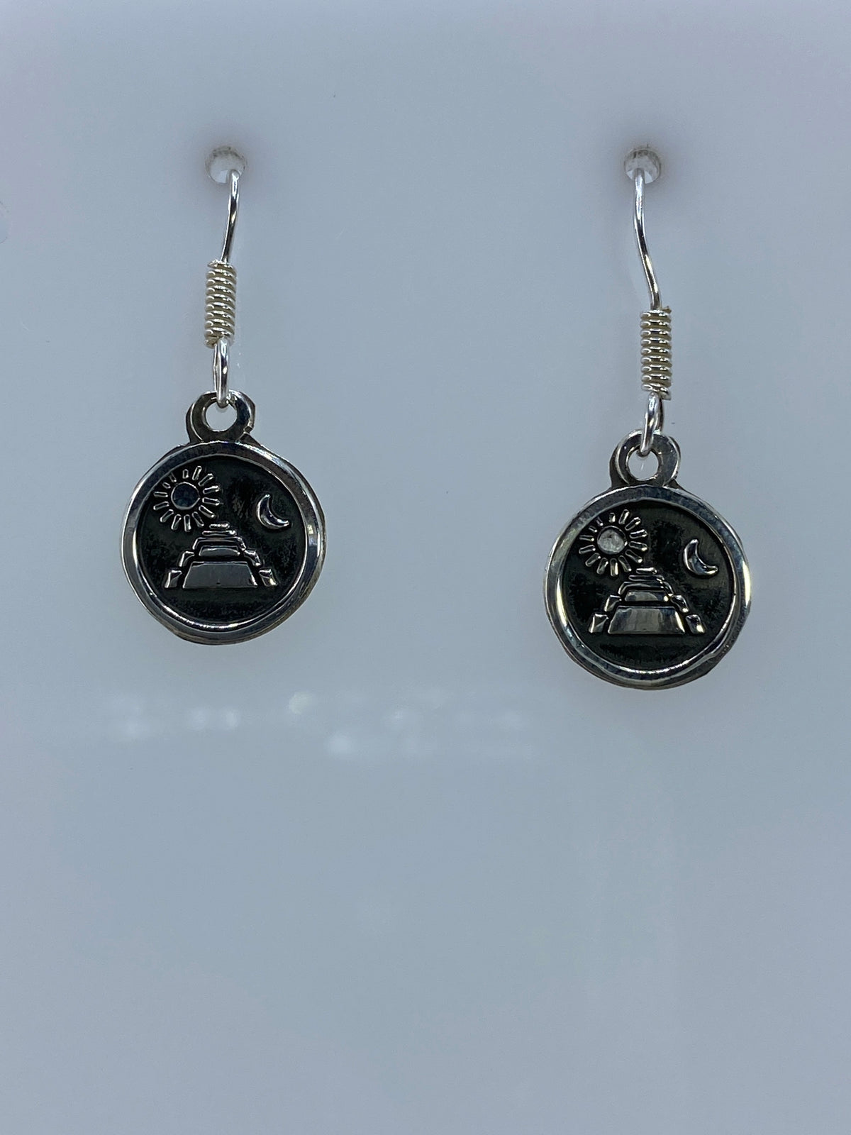 Detalle del relieve repujado en aretes de plata — trabajo manual de Taxco