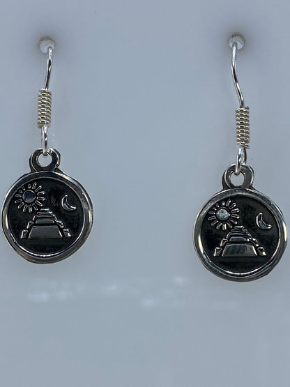 Aretes prehispánicos de plata sobre regla mostrando largo de 2.4 cm