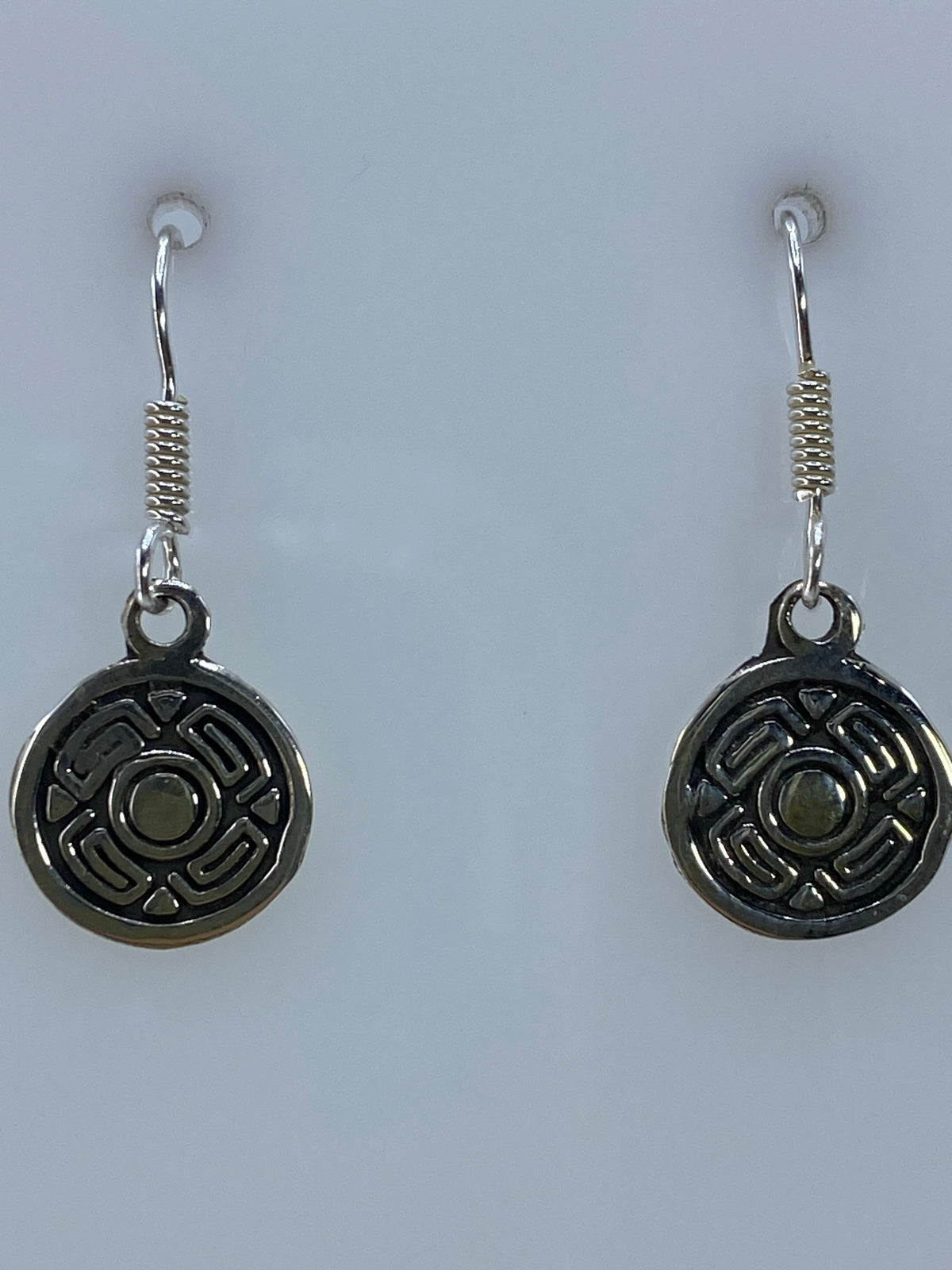Aretes sobre regla de medición mostrando largo de 2.5 cm del par